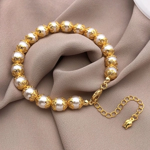 Close-up of vintage pearl bracelet with gold filigree accents and lobster clasp extension