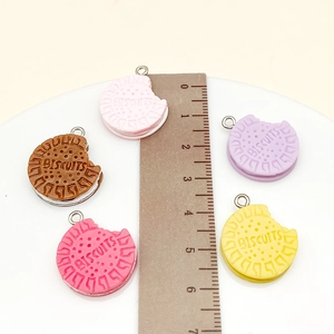 Macro shot of 2.3cm resin cookie charms in multiple colors with silver metal loops