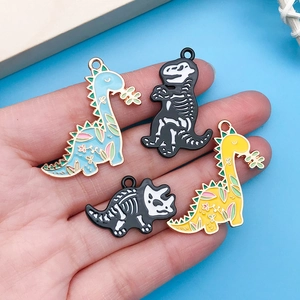 Detail showing four assorted enamel dinosaur charms for DIY jewelry making and crafts
