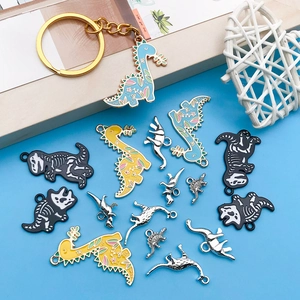 Detailed view of colorful enamel and silver dinosaur alloy charms on light blue background