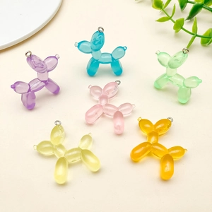 Flat lay of colorful resin balloon dog charms with metal rings for DIY jewelry projects