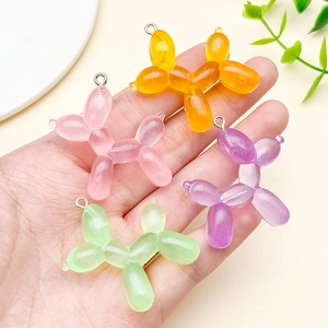 Detail of colorful resin balloon dog pendants with silver rings for DIY crafts