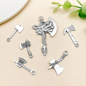 Detail of vintage silver dragon axe pendants for DIY jewelry making and crafts