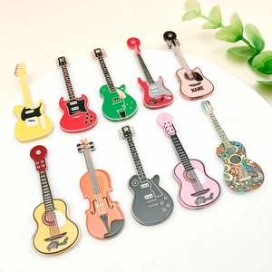 Detailansicht bunter Gitarren- und Violinenanhänger aus Acryl auf einem weißen Tablett