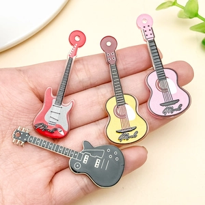 Detailansicht der Acryl-Gitarrenanhänger in verschiedenen Farben in der Hand zur Größe