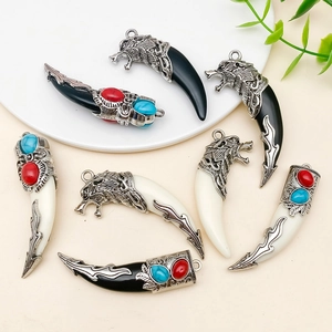Detail van hars hangers in tribale stijl met wolfskop metalen kappen en turquoise details