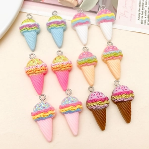 Flat lay of colorful resin ice cream cone pendants with rainbow sprinkles for DIY crafts