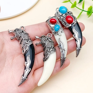 Close-up van vintage zilveren wolfskop hangers met rode en blauwe kralen voor sieraden