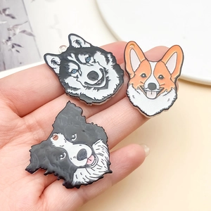 Gros plan de pendentifs en acrylique représentant un Husky, un Corgi et un Border Collie