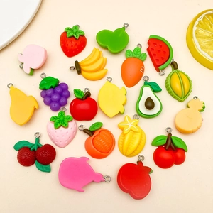 Vista piatta di ciondoli colorati in resina a forma di frutta e verdura per DIY