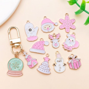 Detail of pink enamel Christmas charms featuring Santa and reindeer on golden alloy