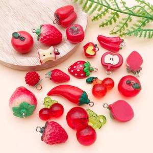 Detailed view of red resin fruit and vegetable charms like strawberry and chili with eyelets