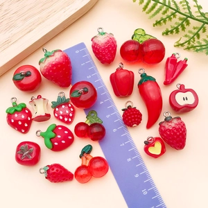 Red resin vegetable and fruit charms for DIY jewelry making displayed with a ruler