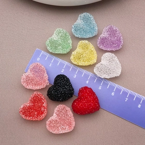 Dettaglio macro di perline a cuore colorate da 2cm con trama di zucchero per gioielli DIY