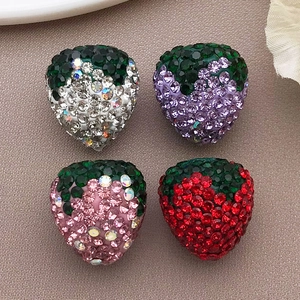 Detalle de cuatro dijes de fresa con pedrería para la creación de joyas y accesorios DIY