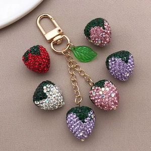 Detalle de colgantes de fresas con cristales multicolores en un cierre chapado en oro