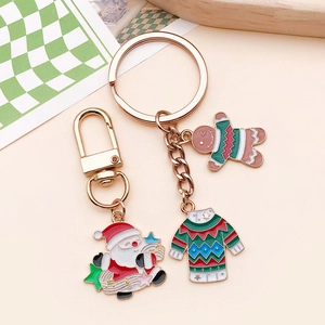 Detailed view of Christmas Santa Claus and gingerbread man enamel charms with golden lobster clasp