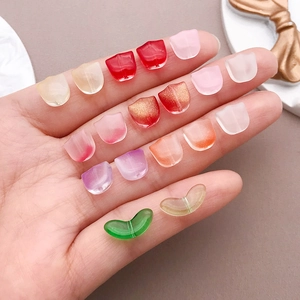 Macro view of colorful tulip-shaped glass beads and leaf charms for DIY jewelry making