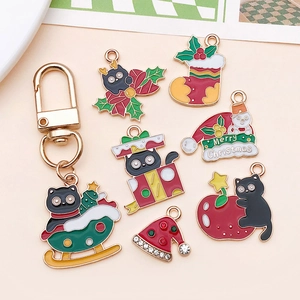 Vue détaillée des breloques de Noël chat en émail et accessoires de porte-clés dorés