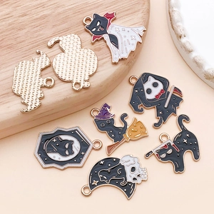 Macro view of Halloween enamel cat charms showing detailed golden fish-scale texture on back
