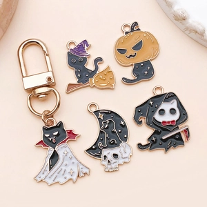 Macro shot of Halloween black cat enamel charms featuring witch, pumpkin and ghost designs