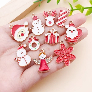 Detailed macro view of 10 festive Christmas alloy charms held in hand for scale