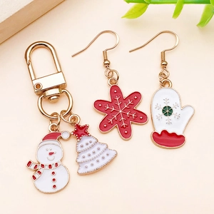 Detail of Christmas themed alloy charms with colorful enamel finish on a beige background