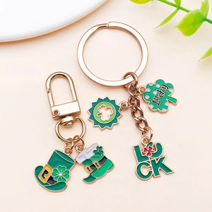 Macro shot of St. Patrick's Day charms with green lucky clovers and boots on gold alloy