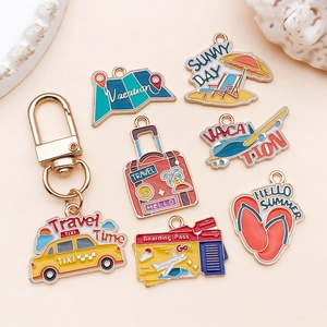 Detailed close-up of colorful enamel vacation charms including suitcase and airplane