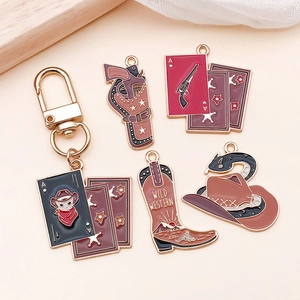 Detail of vintage Western enamel charms featuring cowboy boots, pistols and skull motifs