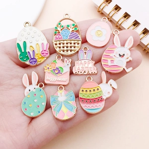 Handheld view of Happy Easter enamel charms including rabbits and eggs for DIY jewelry