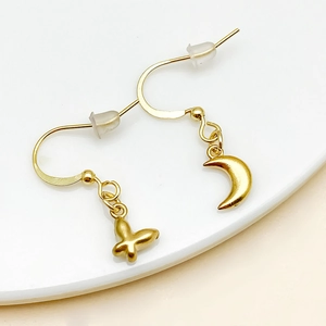 Detail of asymmetric gold plated butterfly and crescent moon charm earrings set
