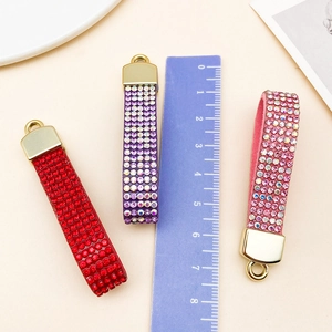 Close-up of velvet rhinestone lanyards in red, purple, and pink with gold clasps