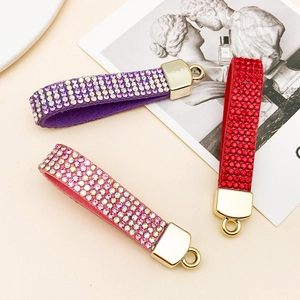Three rhinestone-studded velvet lanyards in purple, red, and pink with golden rings