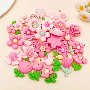 Detailed view of DIY resin flower pendants in soft pink tones with metal hanging loops