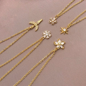 Chaînes plaquées or 18 carats avec pendentifs étoile, fleur et lune sur tissu rose