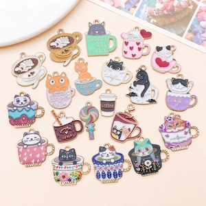 Detailed flat lay of cute enamel cat and coffee cup charms for DIY jewelry making