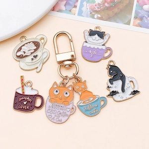 Detailed view of colorful enamel cat in coffee cup charms and golden alloy keychain