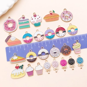 Flat lay of colorful enamel dessert pendants including donuts and cakes for DIY jewelry