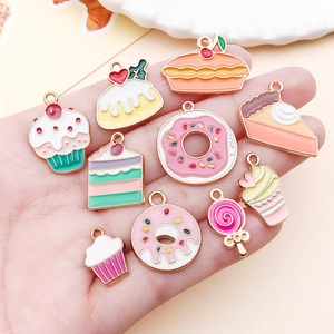 Detailed close-up of mixed alloy enamel dessert charms held in hand for DIY jewelry