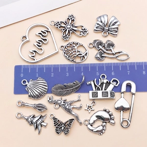 Details von 15 Vintage-Silberanhängern mit Lineal, das Größen von 1-3 cm zeigt