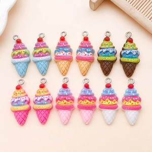 Flat lay of resin ice cream cone pendants with colorful cream toppings and red cherries