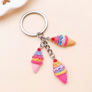 Close-up of three colorful resin strawberry ice cream cone charms on a metal keychain