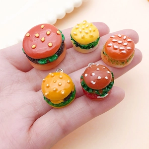 Detailed view of mini resin burger charms showing realistic lettuce and sesame textures