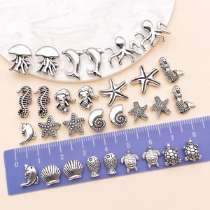 Macro shot of antique silver sea life charms including starfish and turtles for DIY jewelry