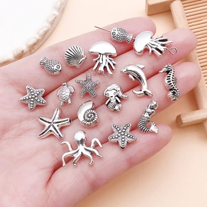 Macro detail of antique silver ocean themed charms and beads for DIY jewelry making
