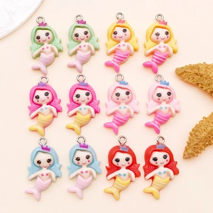 Detailed view of twelve colorful resin mermaid charms with metal rings for DIY jewelry