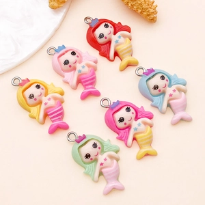 Detail of six colorful resin mermaid pendants with silver loops for DIY jewelry making