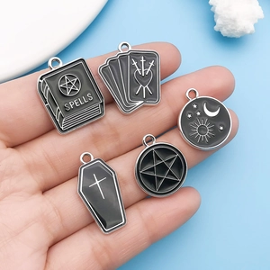 Detailed macro of black enamel dark style magic spell and tarot card charms for DIY jewelry