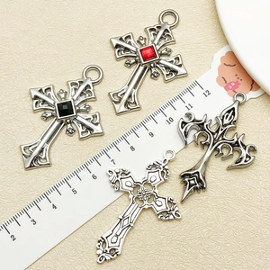 Detailed close-up of retro silver cross pendants with gemstone inlays and hollow patterns